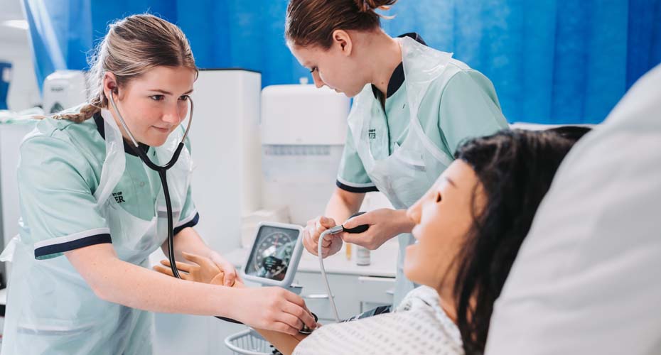 Nursing students with stethoscope and testing blood pressure
